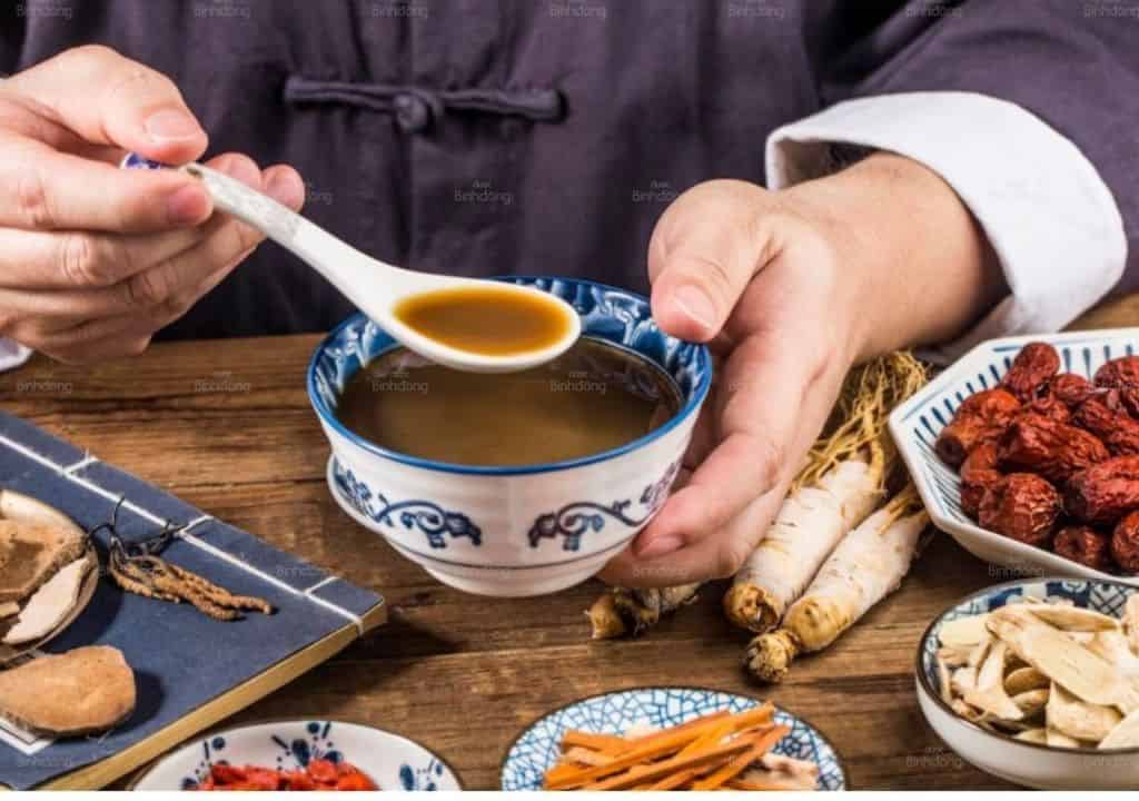 Hình ảnh người lương y đang sắc thuốc