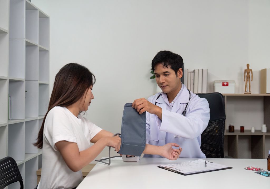 Hình ảnh người bác sĩ đang đo huyết áp cho bệnh nhân