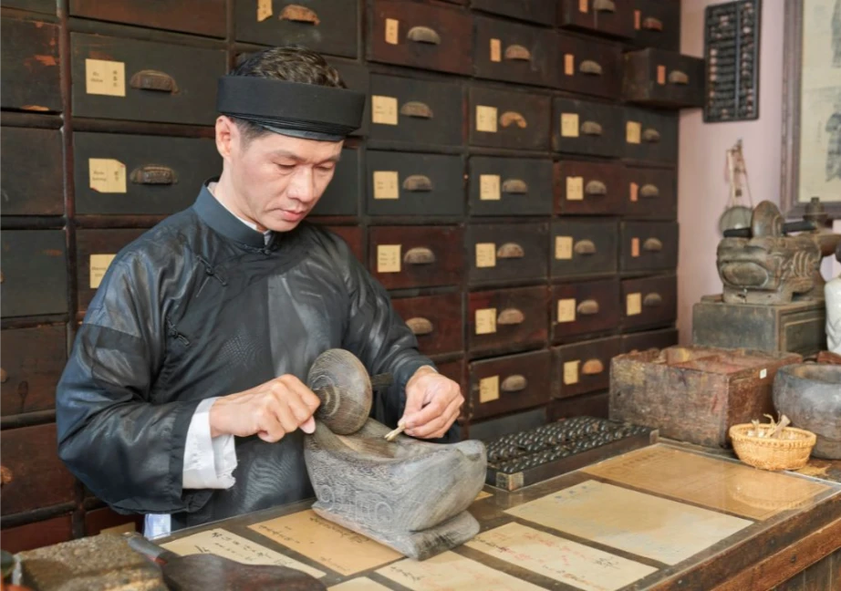 Hình ảnh người lương y đang sắc thuốc