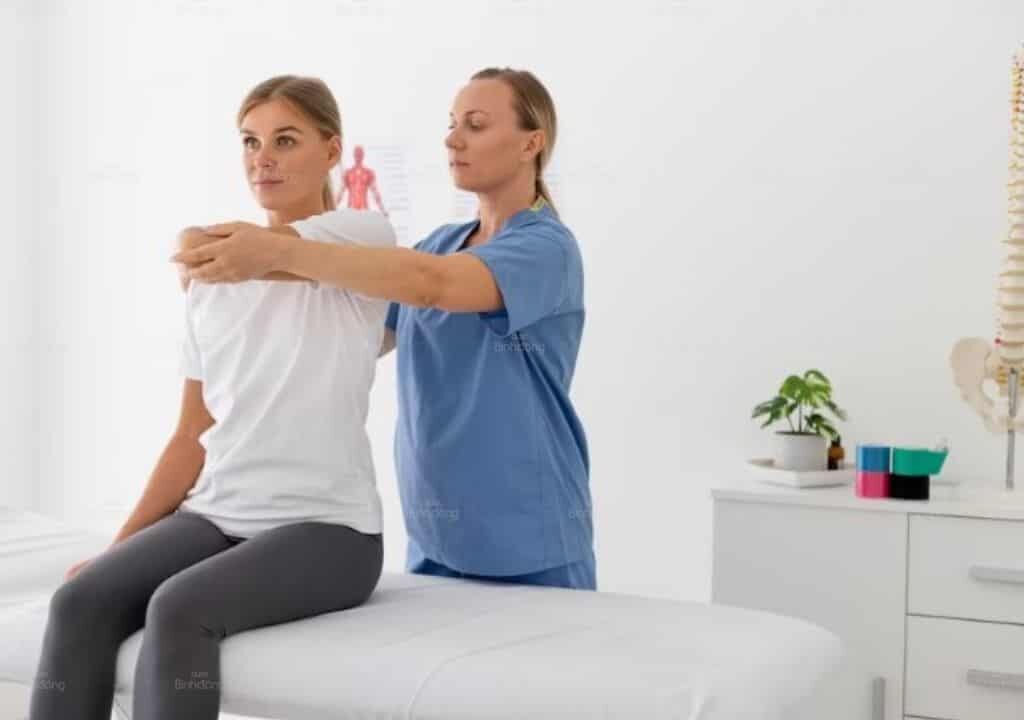 Người phụ nữ đang xử dụng liệu pháp vật lý trị liệu giúp giảm triệu chứng viêm quanh khớp vai