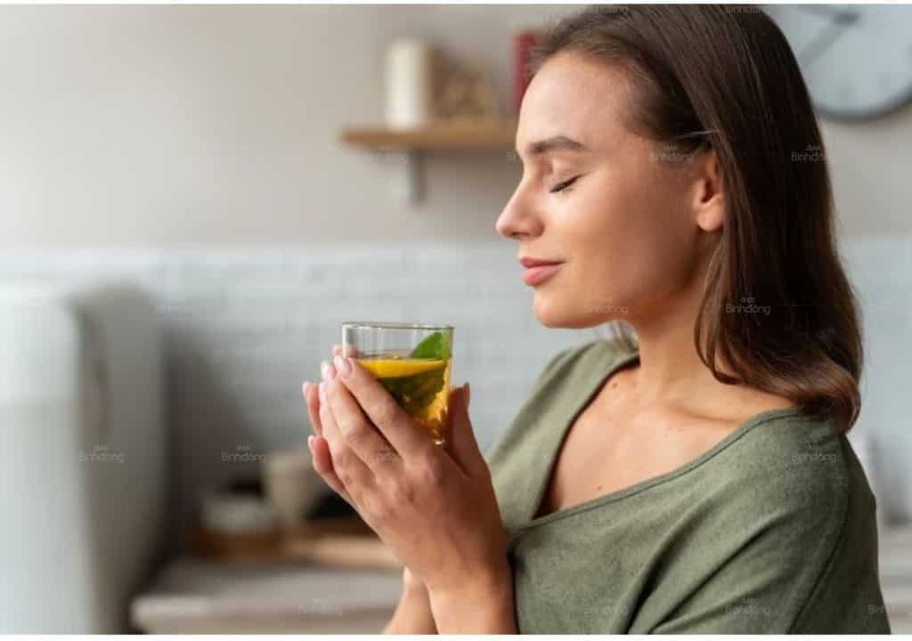 Hình ảnh người phụ nữ uống trà xanh để giảm căng thẳng