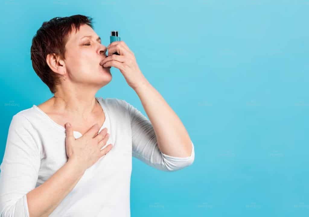 Hình ảnh người phụ nữ đang dùng thuốc điều trị hen suyễn