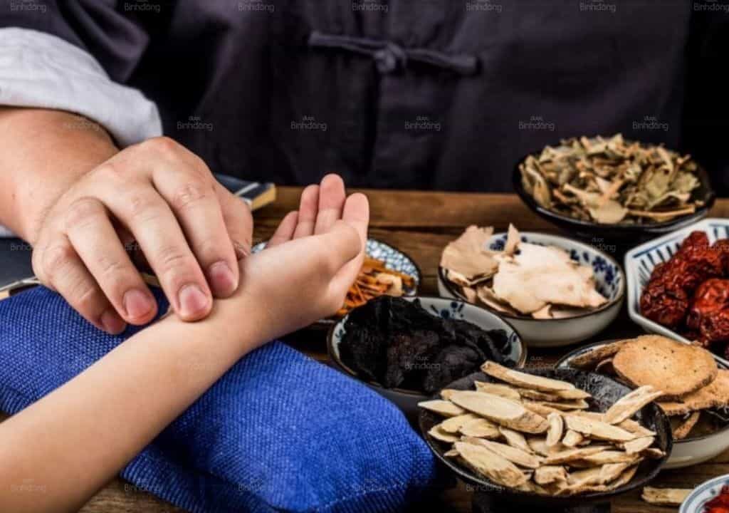 Hình ảnh thầy thuốc đang bắt mạch chẩn bệnh cho bệnh nhân