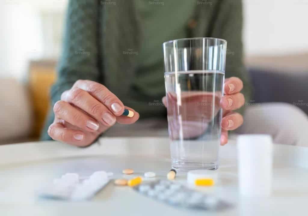 Hình ảnh người phụ đang chuẩn bị uống thuốc