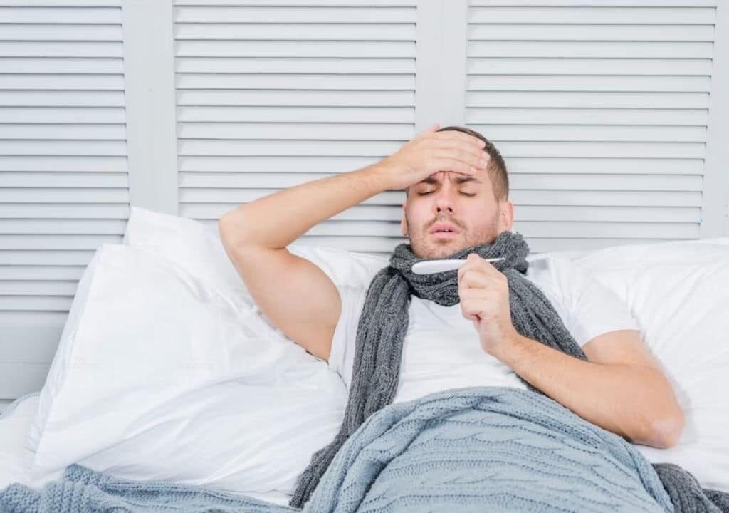 Hình ảnh người đàn ông đang bị sốt trên giường bệnh