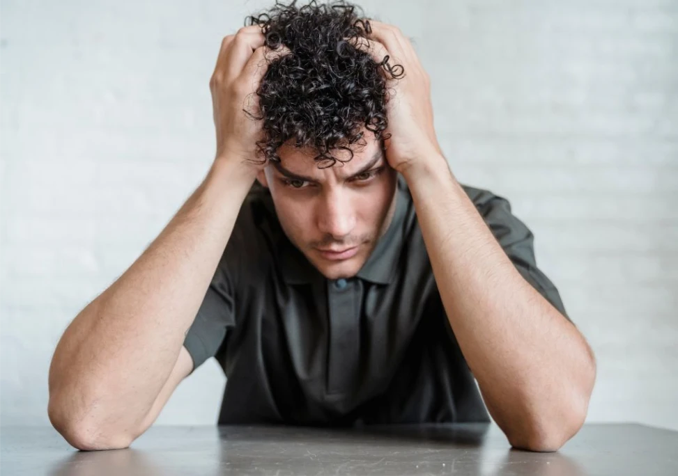 Nam giới ôm đầu vì lo lắng về chức năng sinh lý khi thận yếu