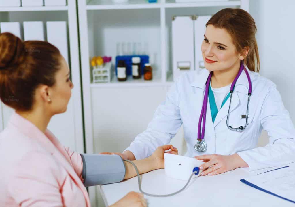 Hình ảnh người bác sĩ đang tư vấn cho bệnh nhân về tình trạng nước tiểu có màu nâu hồng