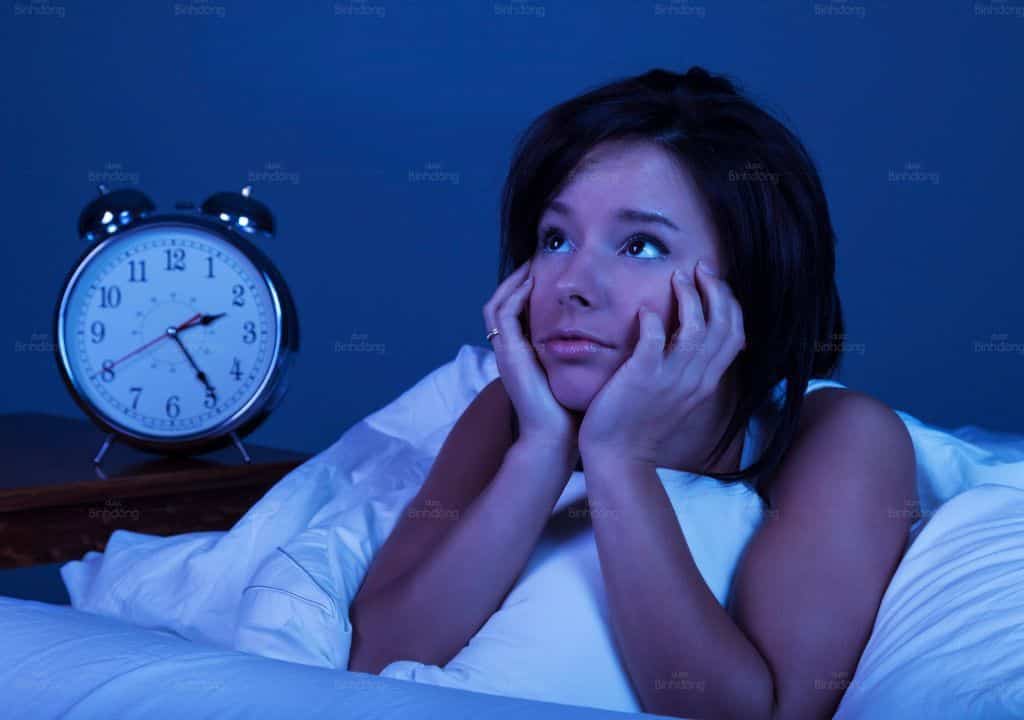 Hình ảnh người phụ nữ đang bị mất ngủ do bị nổi mề đay ngứa về đêm