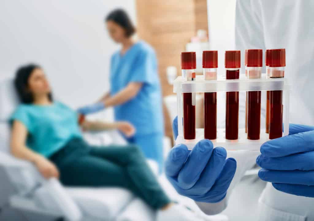 Hình ảnh người bác sĩ đang xét nghiệm máu cho bệnh nhân