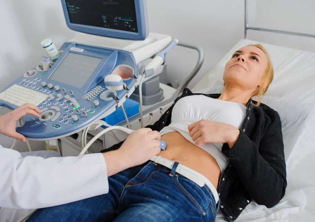 Bác sĩ siêu âm để chuẩn đoán bệnh gây nóng gan, thận yếu