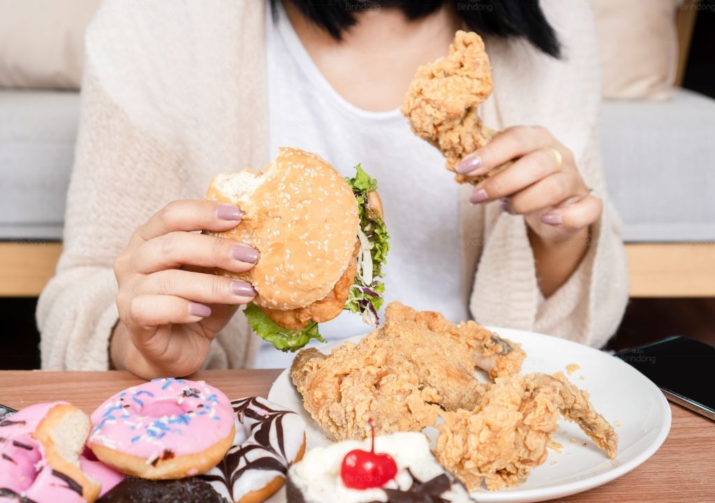 Người phụ nữ đang ăn thức ăn nhanh nguyên nhân chính gây ra tình trạng gan nóng
