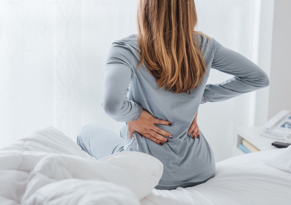 Hình ảnh người phụ nữ đang bị đau lưng âm ỉ