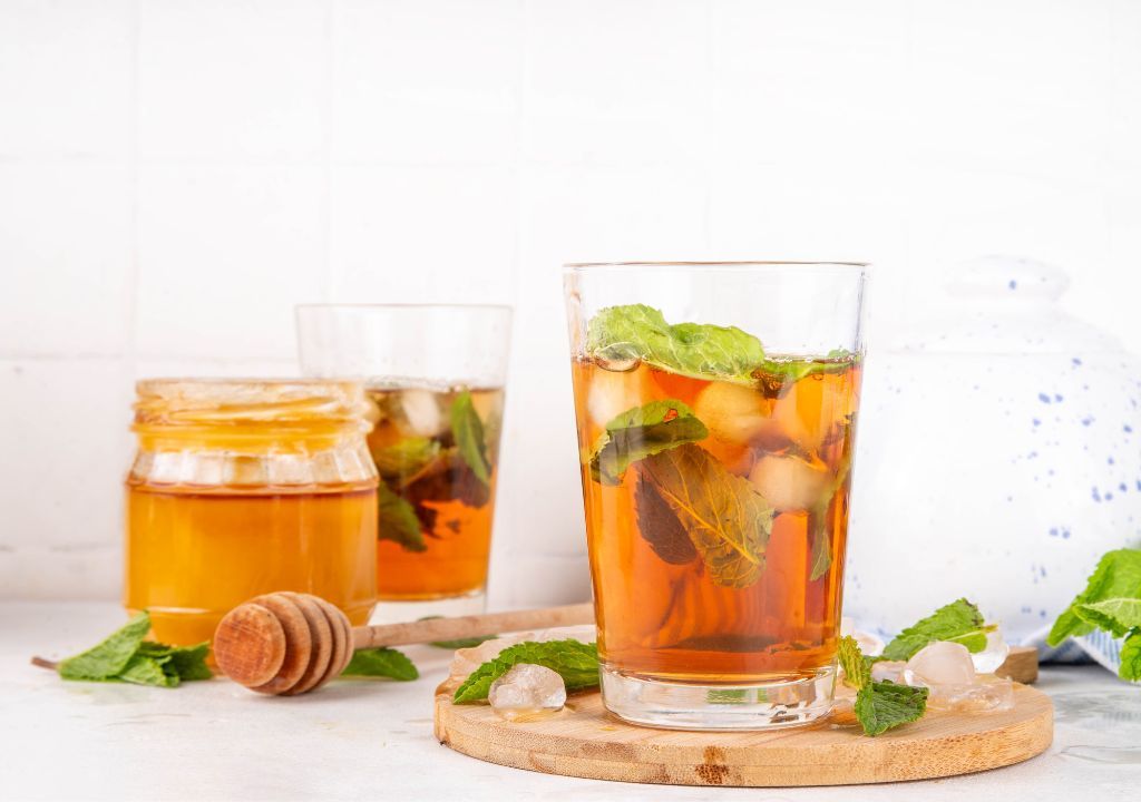 Ly trà bạc hà tươi với lá bạc hà và lát cam, giúp làm dịu cơ thể và hỗ trợ giảm căng thẳng.