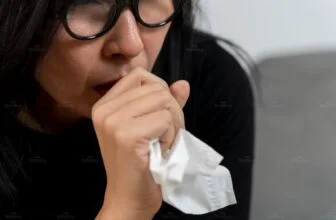Người phụ nữ bị ho, đau họng do thức khuya và cơ thể mệt mỏi, cần chăm sóc cổ họng đúng cách.