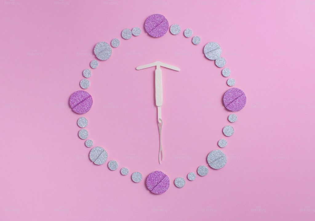 Dụng cụ đặt vòng tránh thai và chu kỳ kinh nguyệt minh họa bằng vòng tròn.