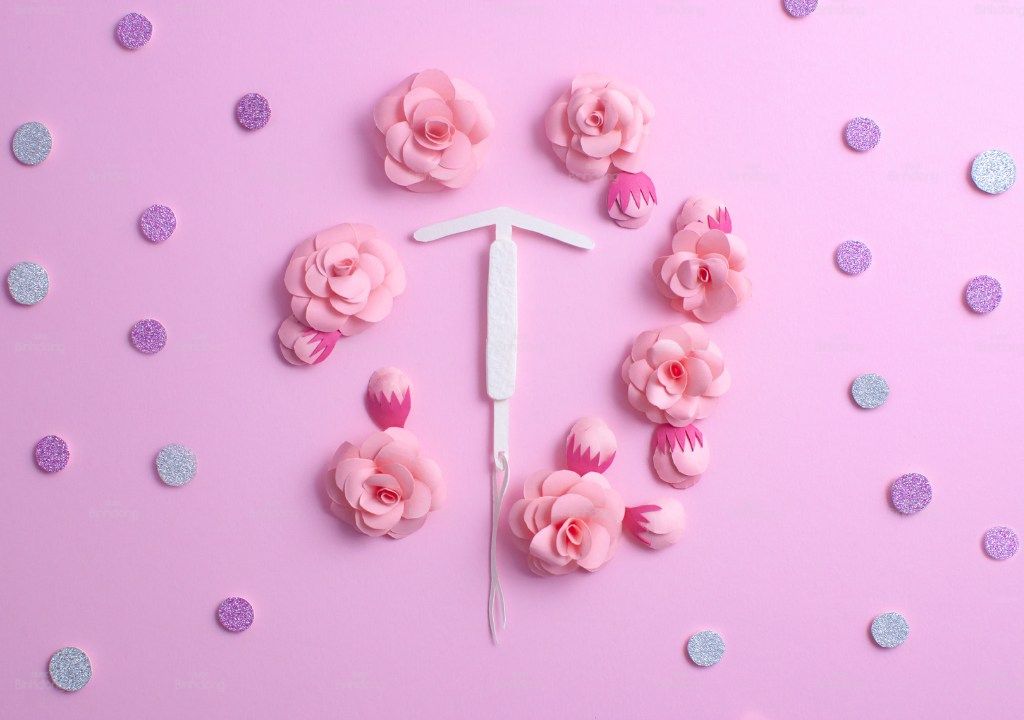 Hình minh họa vòng tránh thai IUD đặt giữa biểu tượng chu kỳ kinh nguyệt.