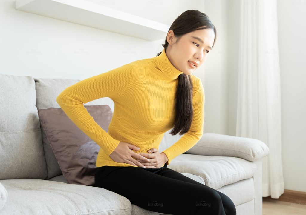 Phụ nữ ôm bụng dưới, khó chịu khi tới tháng bị tiêu chảy