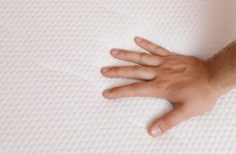 Bàn tay ấn lên bề mặt nệm cứng để kiểm tra độ đàn hồi