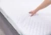 Bàn tay kiểm tra độ đàn hồi của nệm mềm hỗ trợ giấc ngủ ngon