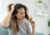 Người phụ nữ lo lắng khi thấy tóc rụng nhiều, gợi ý tình trạng rụng tóc nội tiết.