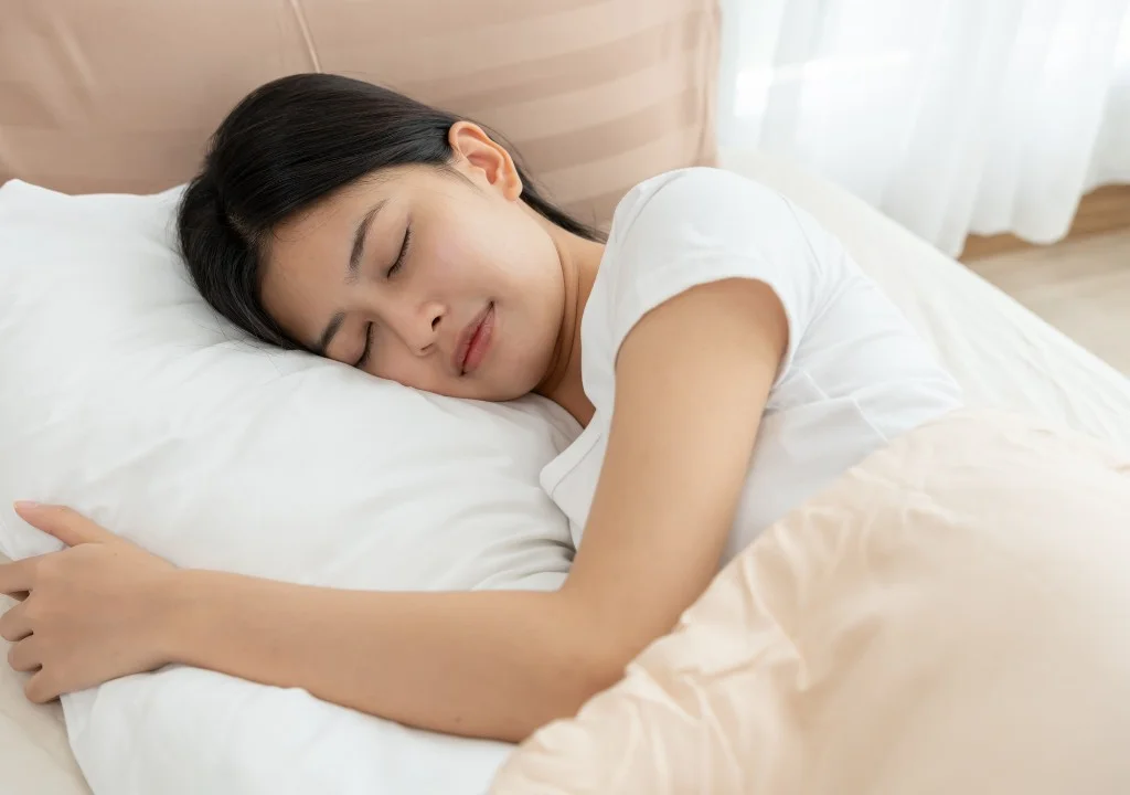 Người phụ nữ nằm nghiêng ngủ thoải mái trên nệm mềm êm ái
