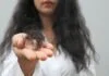 Người phụ nữ cầm viên uống, minh họa tình trạng rụng tóc do thiếu sắt.