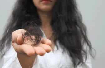 Người phụ nữ cầm viên uống, minh họa tình trạng rụng tóc do thiếu sắt.